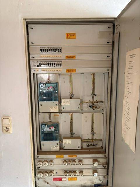 Elektrischer Sicherungskasten und Zähler in einem Versorgungsraum des Gebäudes.