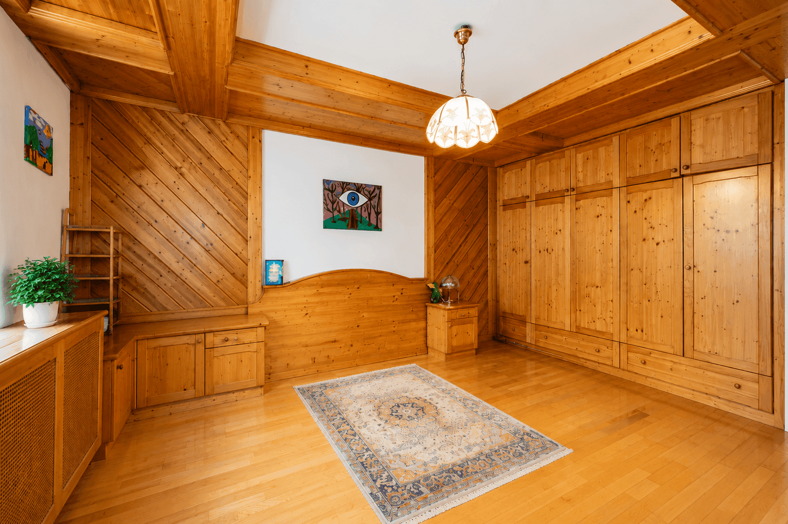 Schlafzimmer mit umfangreichen Einbauschränken aus Holz und rustikalen Holzverkleidungen.