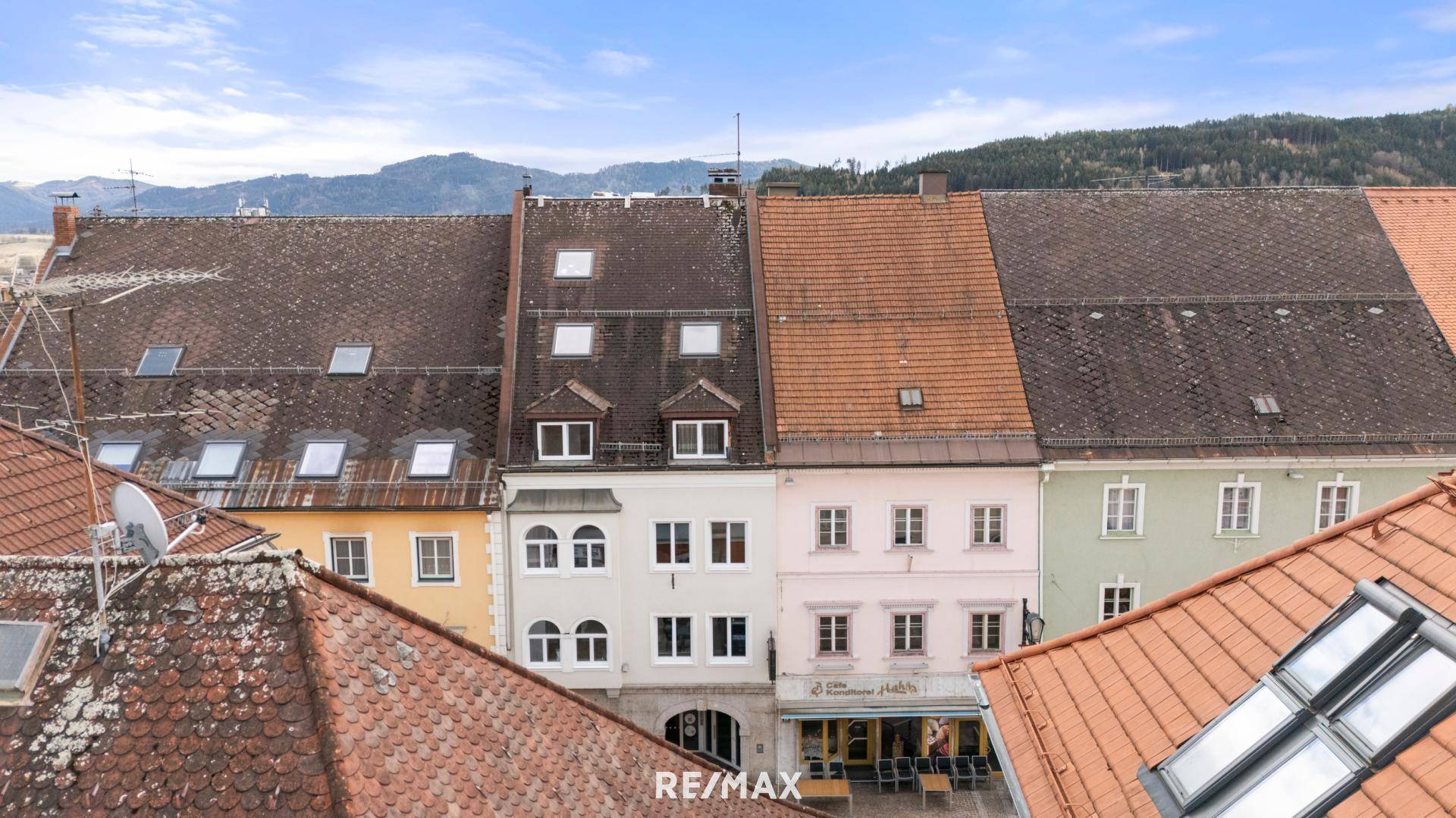 Blick auf die Dächer und Fassaden historischer Gebäude in einer städtischen Umgebung.