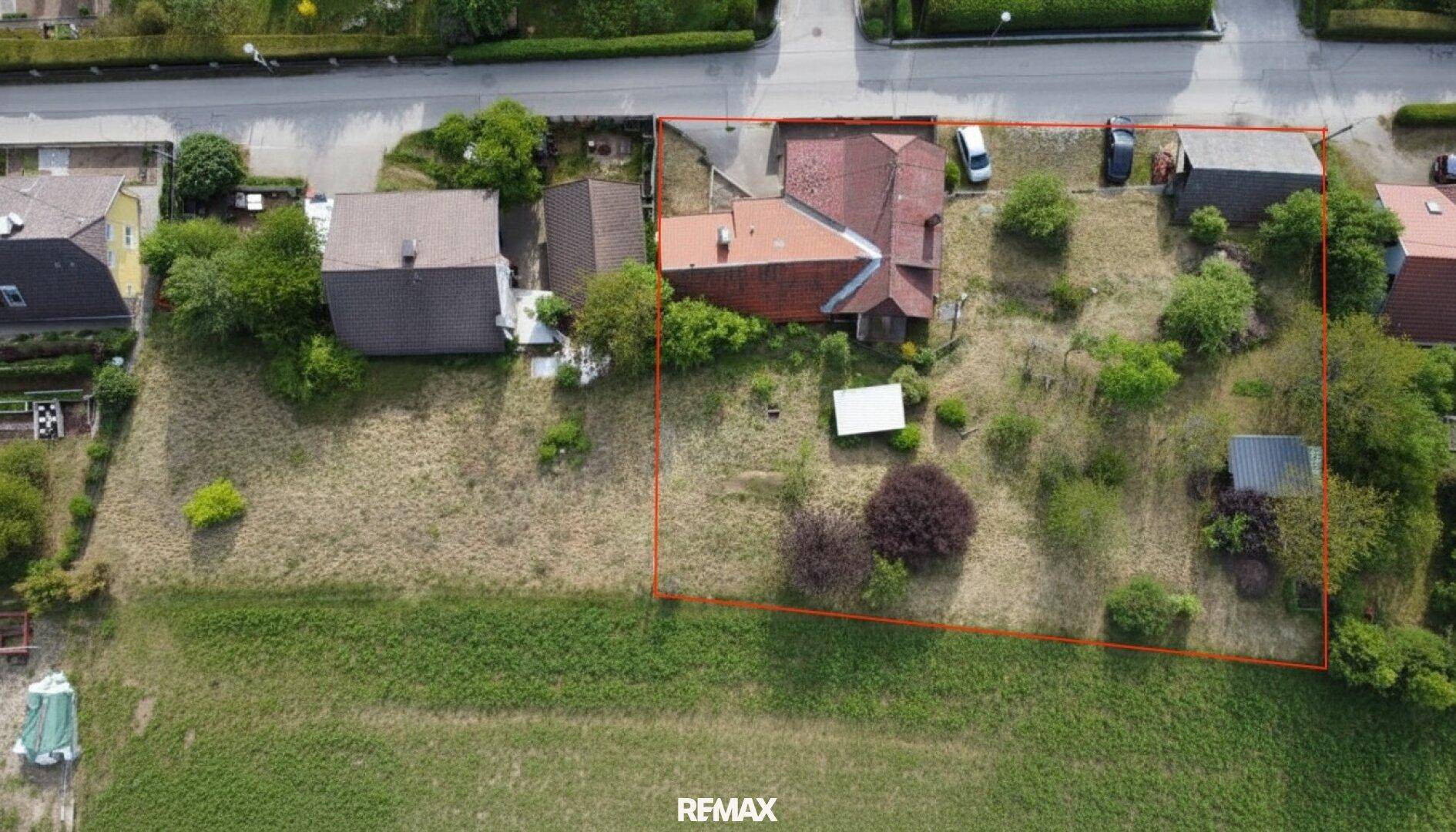 Senkrechte Luftaufnahme des Grundstücks mit Wohnhaus und umliegender Grünfläche, deutlich markiert.