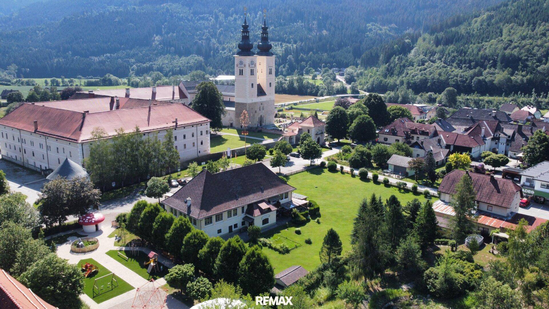 Panoramablick auf das Anwesen und die umliegende ländliche Gegend mit einer markanten Kirche.