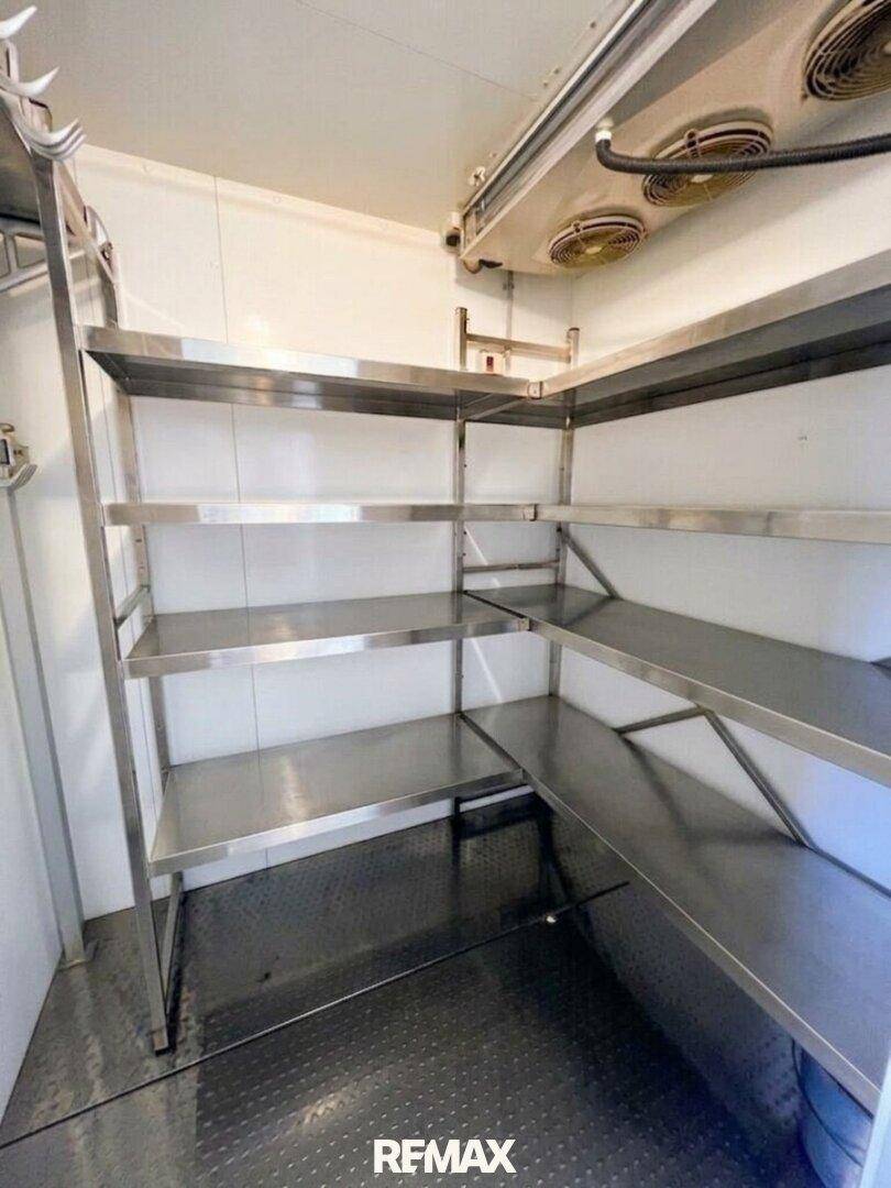 Begehbarer Kühlraum mit robusten Edelstahlregalen für die Lagerung von Lebensmitteln.