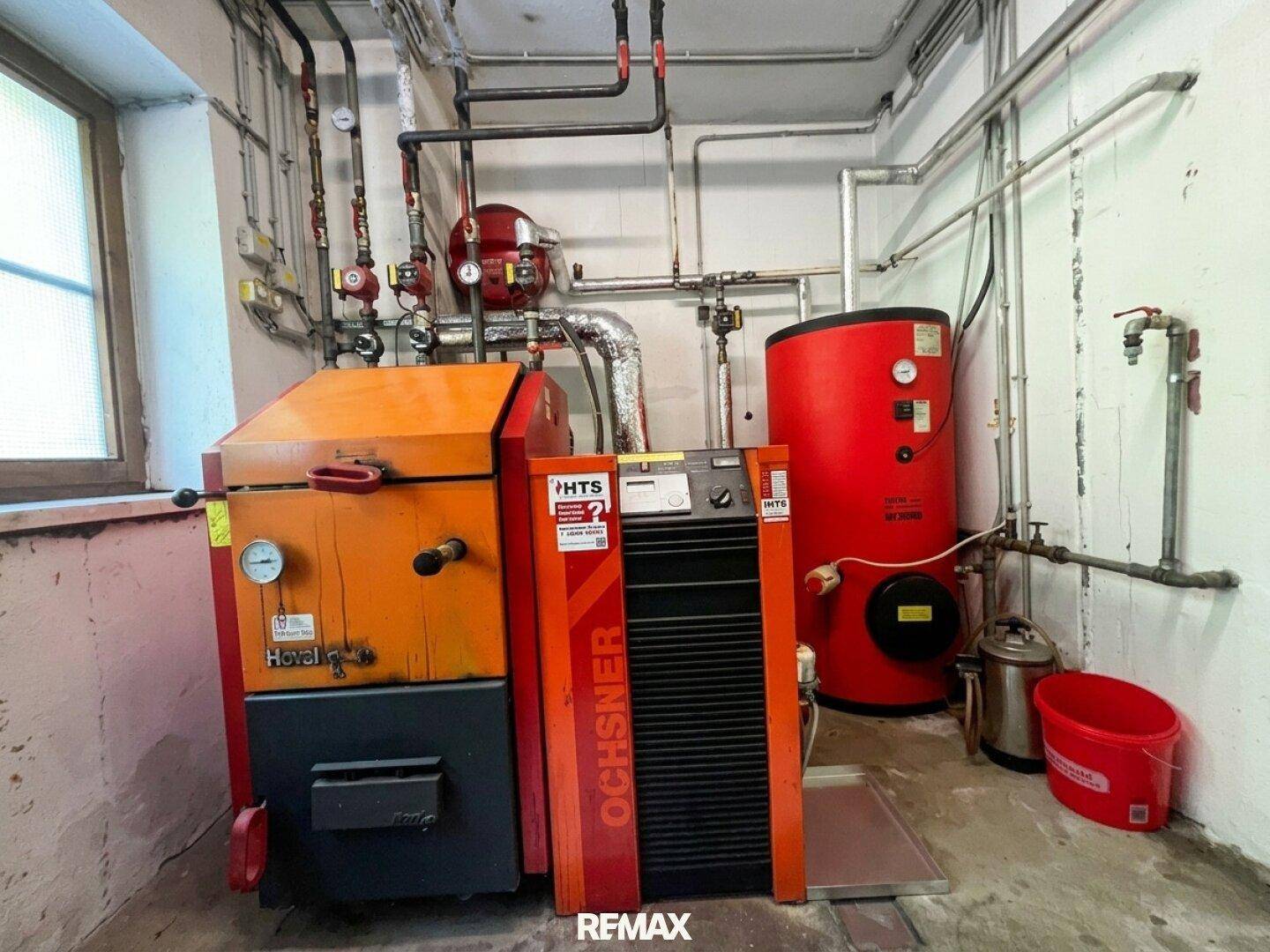 Heizungsraum mit großem Heizkessel und Warmwasserspeicher für die Gebäudewärmeversorgung.
