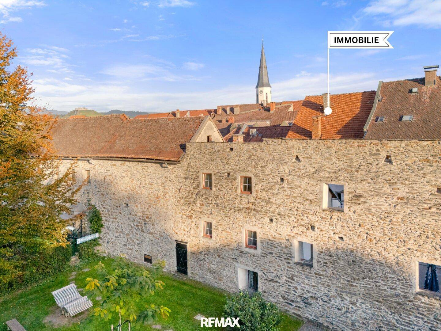 Vogelperspektive auf die historische Stadtmauer und die umliegenden Gebäude mit grünen Gärten.