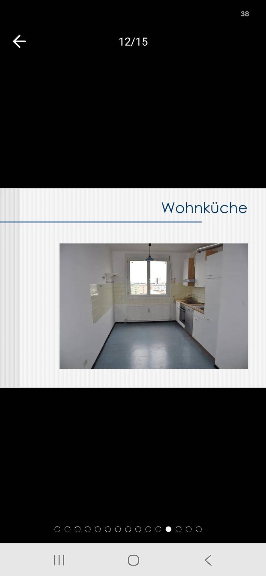 Helle Wohnküche mit weißen Einbauschränken, blauen Fliesen und einem Fenster.