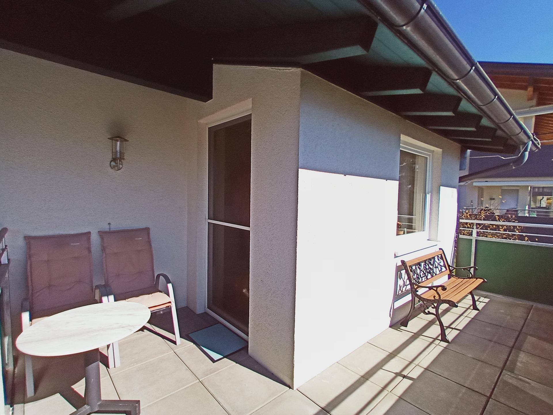 Heller Balkon mit Sitzgelegenheiten und Blick auf die Umgebung.