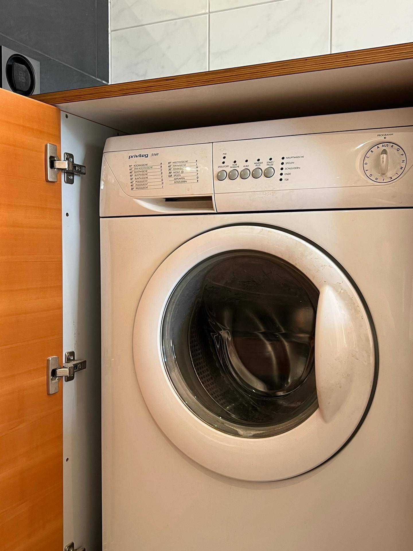Waschmaschine in einem Einbauschrank, ideal für einen praktischen Hauswirtschaftsraum.
