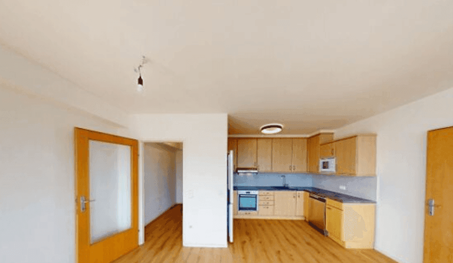 Funktionale Einbauküche mit Holzschränken, modernen Geräten und ausreichend Arbeitsfläche.