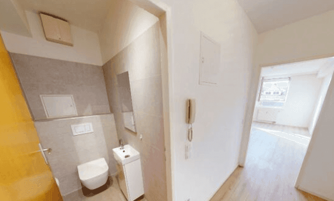 Kleines Gäste-WC mit Wand-WC, Handwaschbecken und modernen grauen Fliesen.