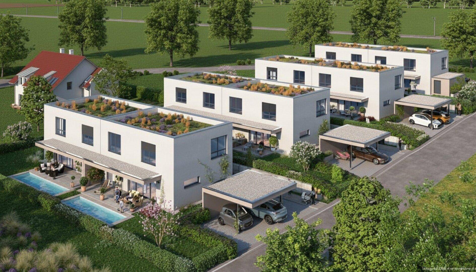 Luftaufnahme einer modernen Wohnsiedlung mit Reihenhäusern, Gründächern und Carports.