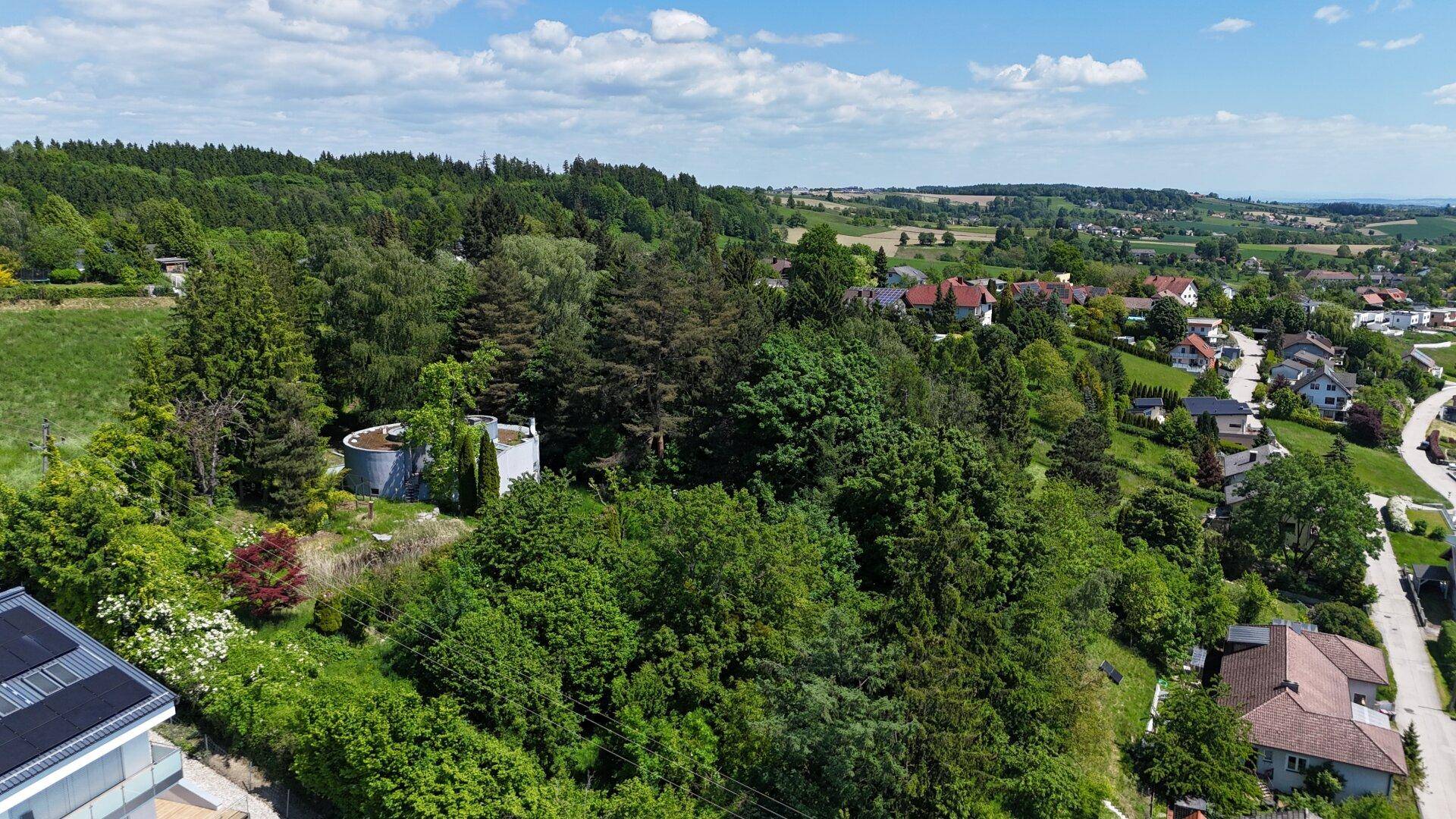 Weitläufige Luftaufnahme der ländlichen Umgebung mit dem modernen Haus und angrenzenden Wohngebieten.