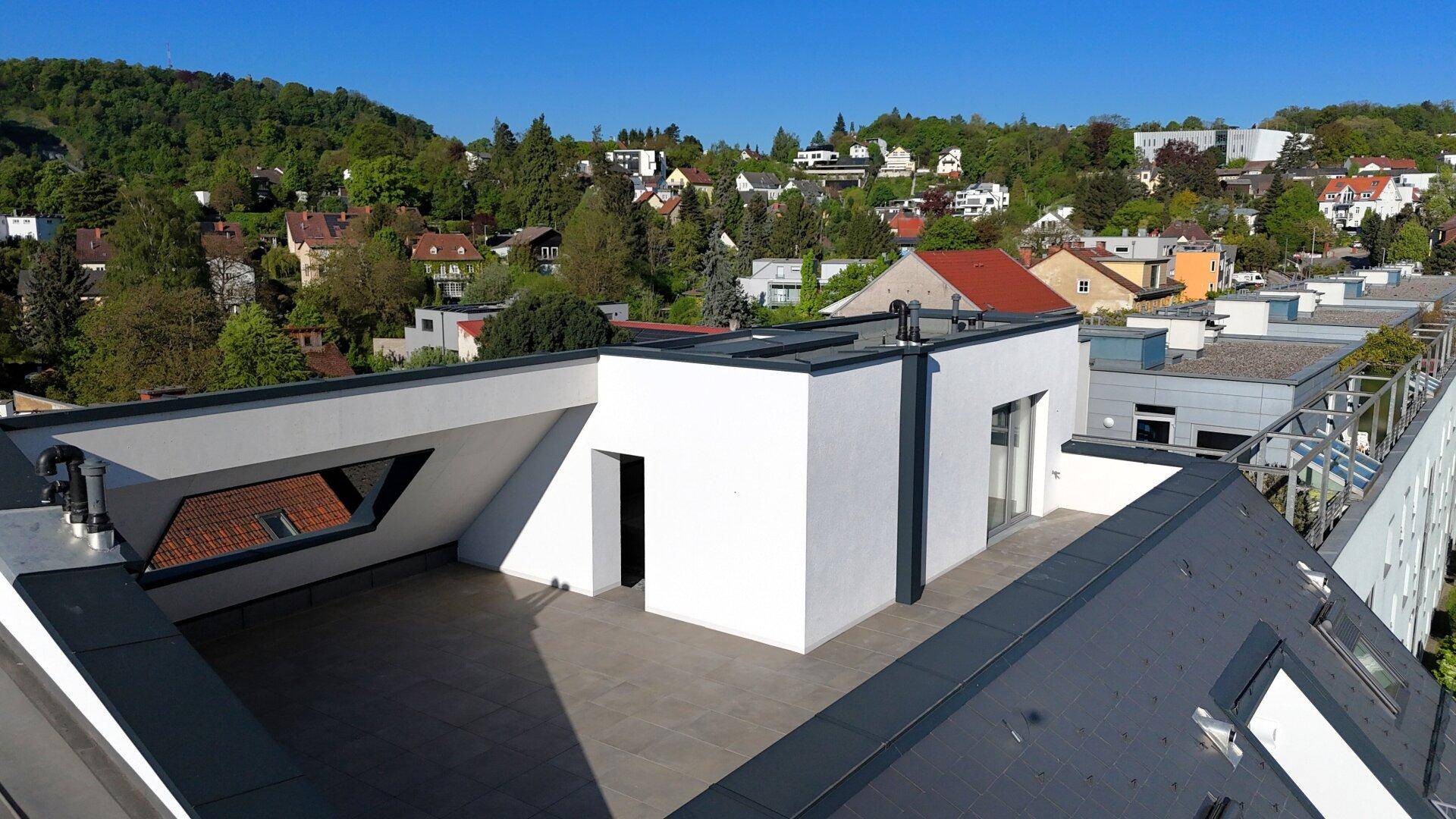 Geräumige Dachterrasse mit moderner Gestaltung und weitem Blick über die Umgebung.