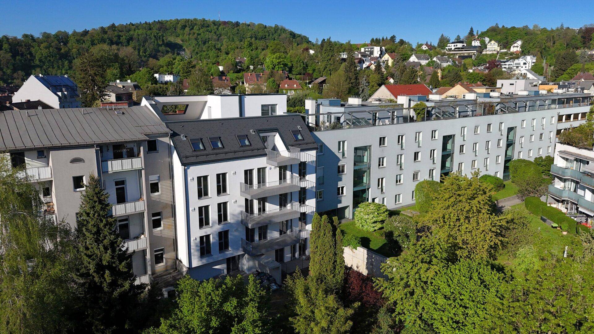 Gesamtansicht des modernen Wohnkomplexes mit mehreren Gebäudeteilen und Grünflächen.