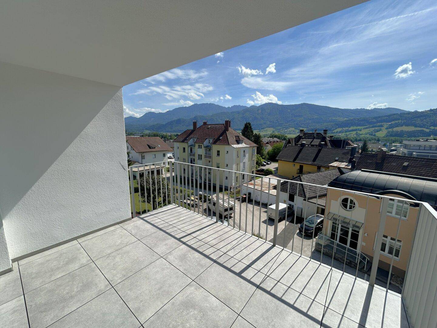 Geräumiger Balkon mit weitem Blick auf die umliegende Stadt und die malerischen Berge.