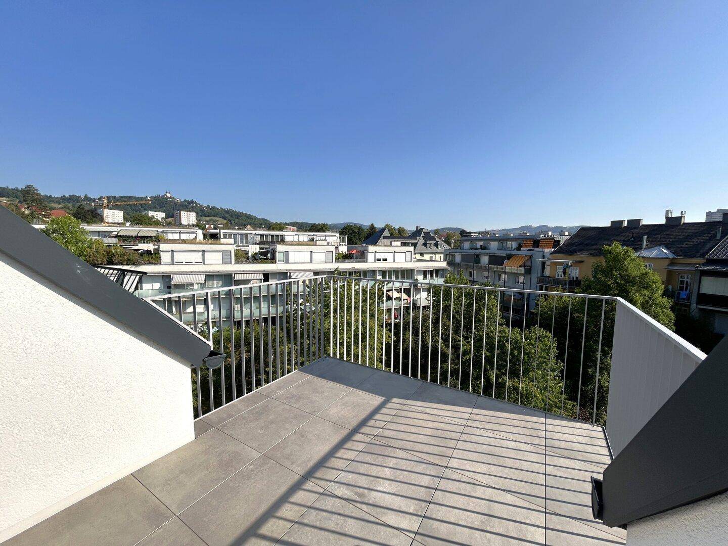 Weitläufiger Ausblick vom Balkon über die Stadt und grüne Hügellandschaft.