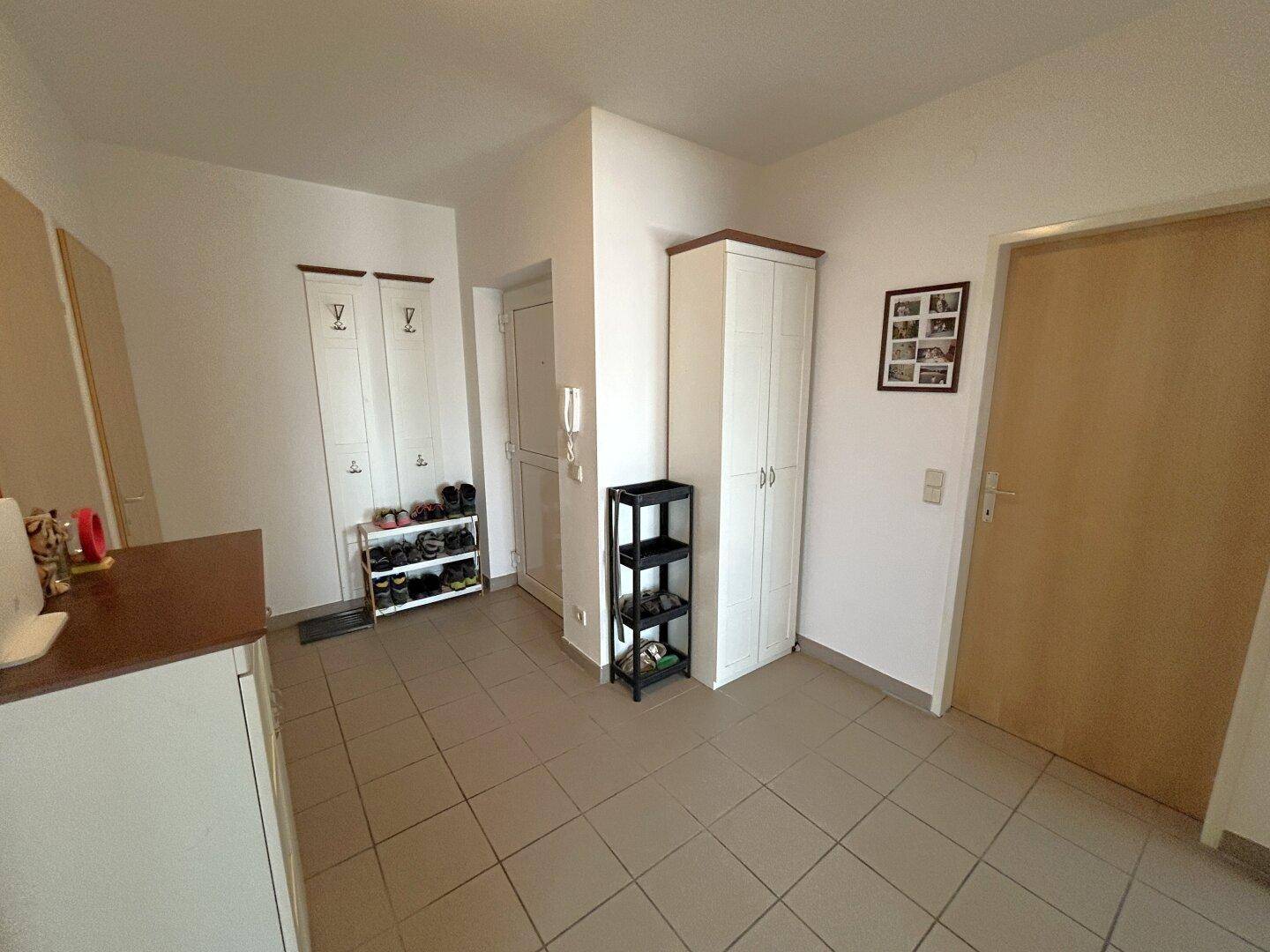 Eingangsbereich mit Fliesenboden, Garderobe und praktischen Aufbewahrungsmöbeln, hell und funktional.