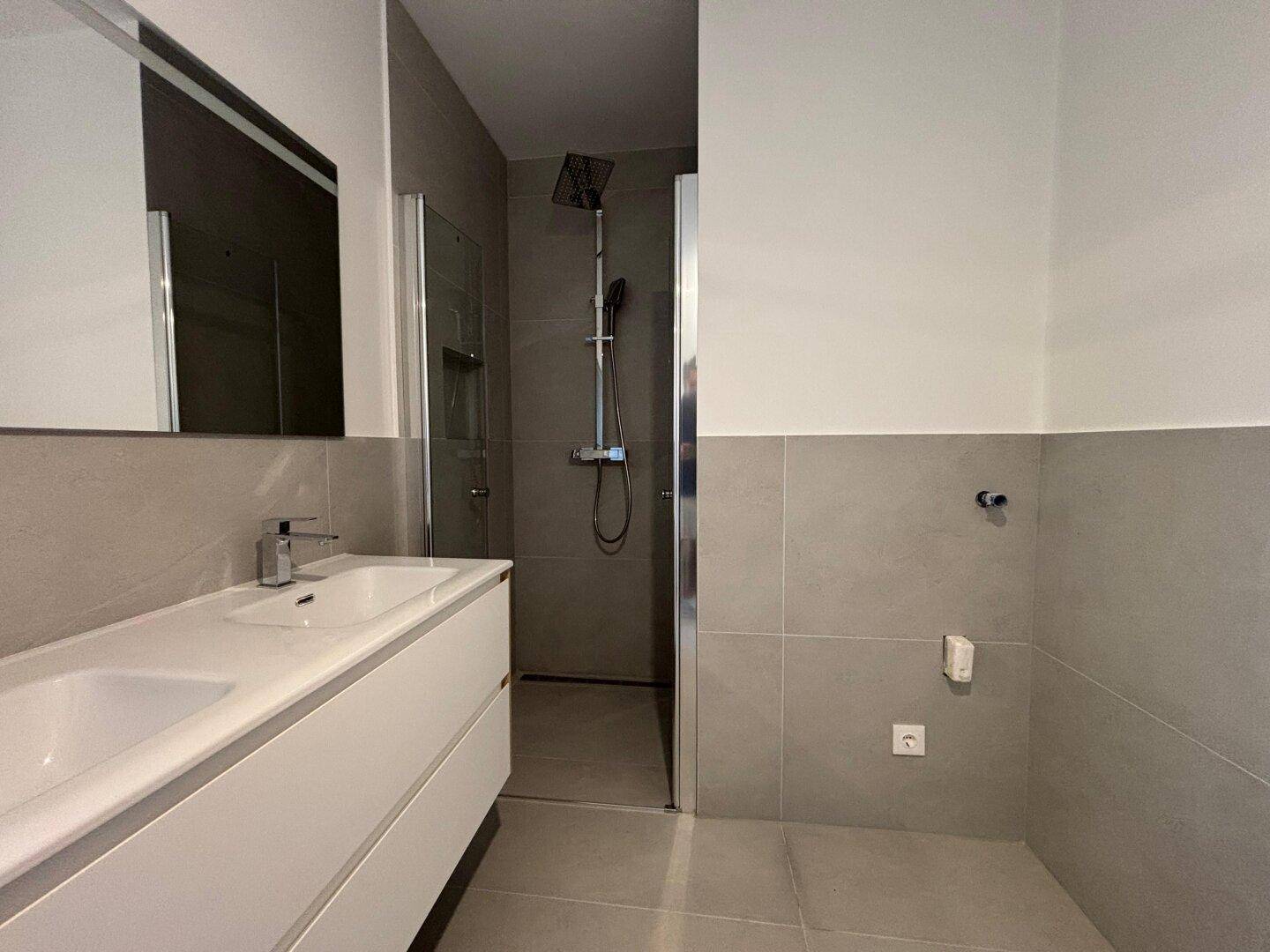 Modernes Badezimmer mit Doppelwaschbecken und geräumiger begehbarer Dusche.