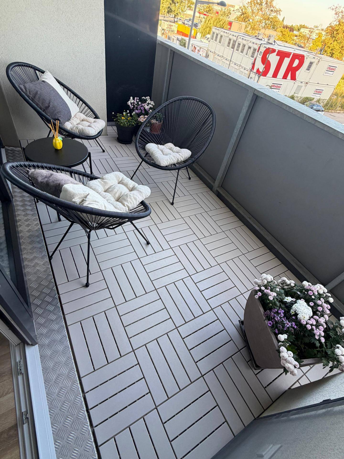 Gemütlicher Balkon mit Sitzgelegenheiten, Fliesenboden und Blick auf die Umgebung.