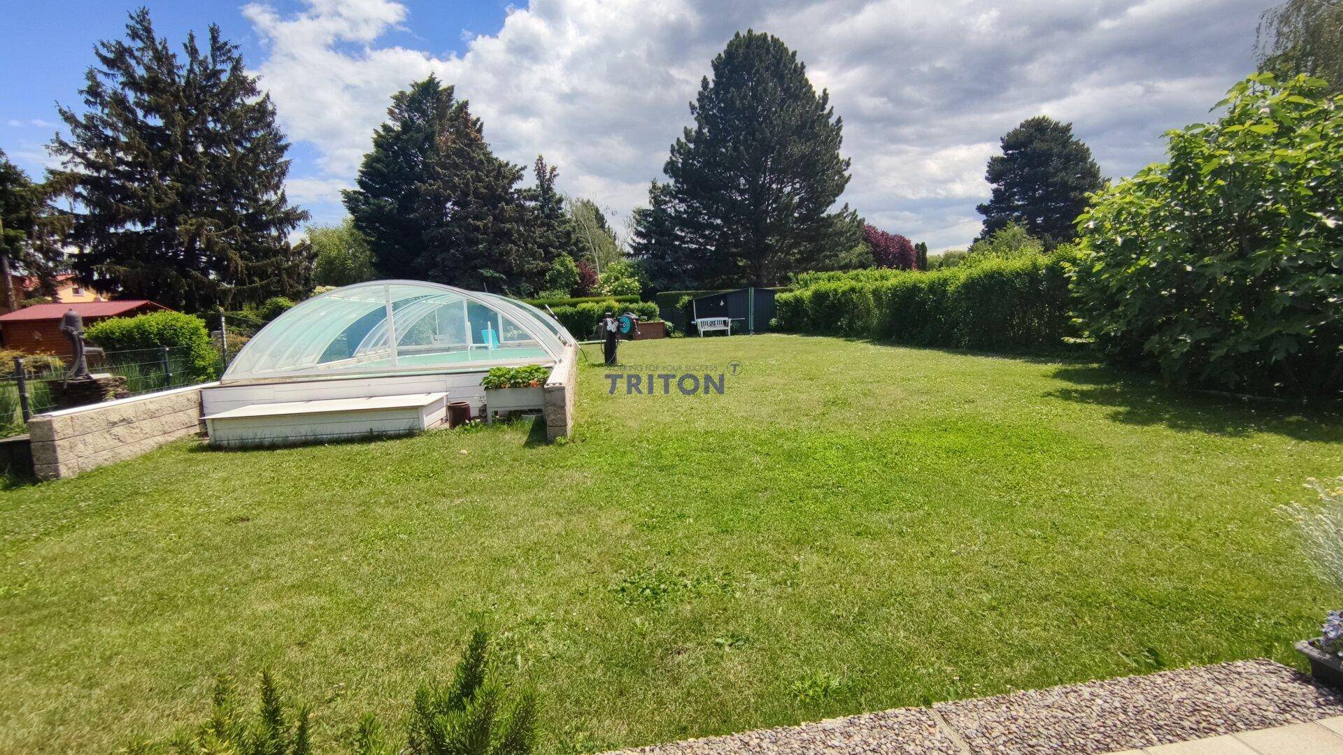 Großer, gepflegter Garten mit weitläufiger Rasenfläche und überdachtem Swimmingpool.