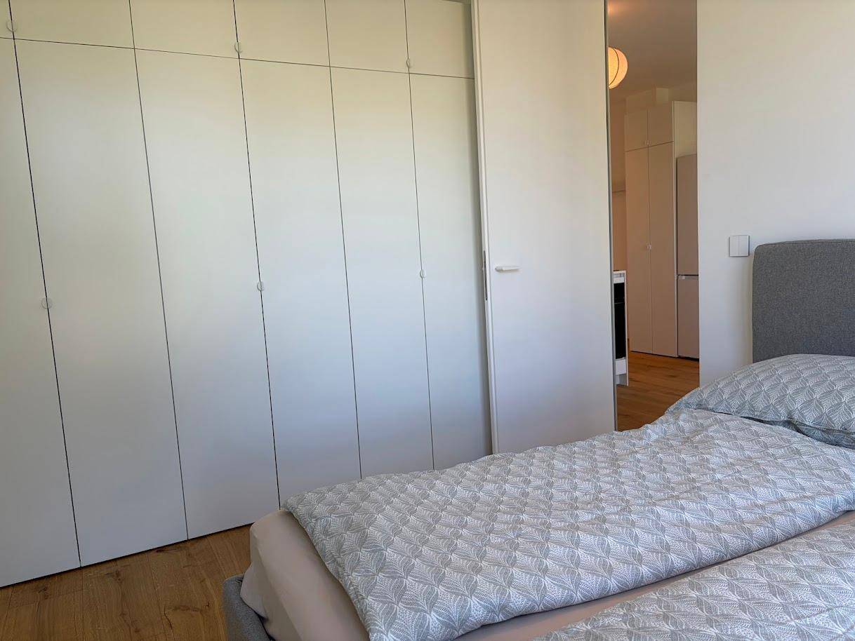 Schlafzimmer mit praktischen Einbauschränken, zwei Einzelbetten und warmem Holzboden.