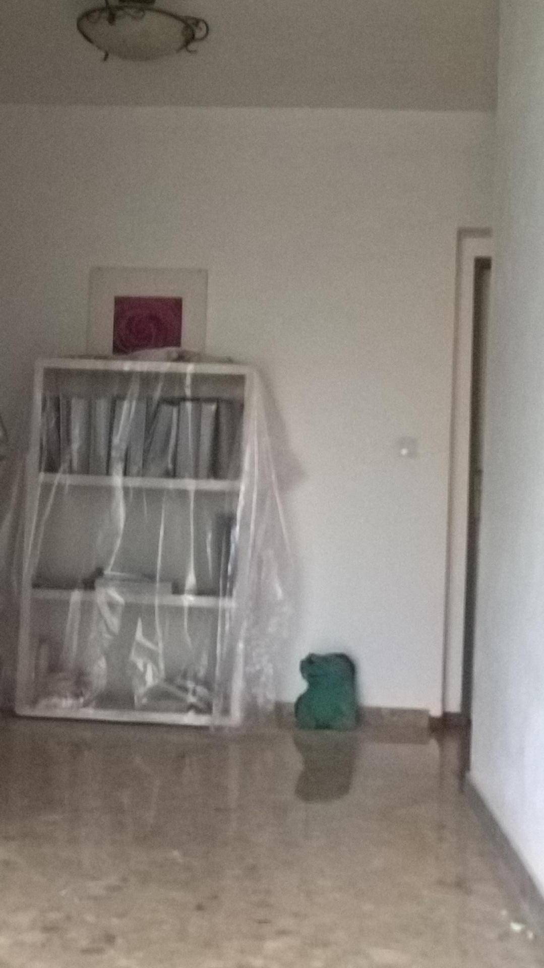 Innenraum mit Regal und schlichten Wänden, der auf weitere Nutzung wartet.