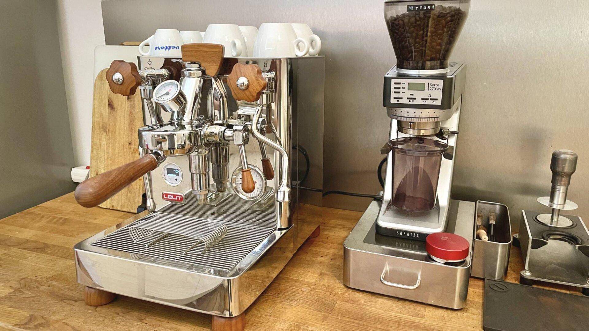 Hochwertige Espressomaschine und Kaffeemühle auf einer Holzarbeitsplatte in der Küche.