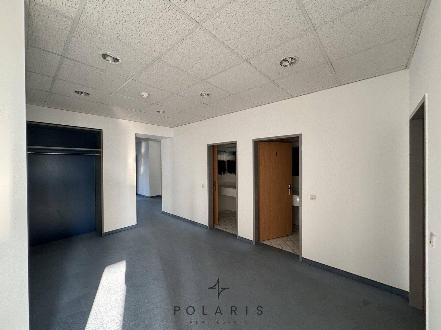 Flur oder Empfangsbereich mit Zugang zu Toiletten und einem dunklen Einbauschrank.