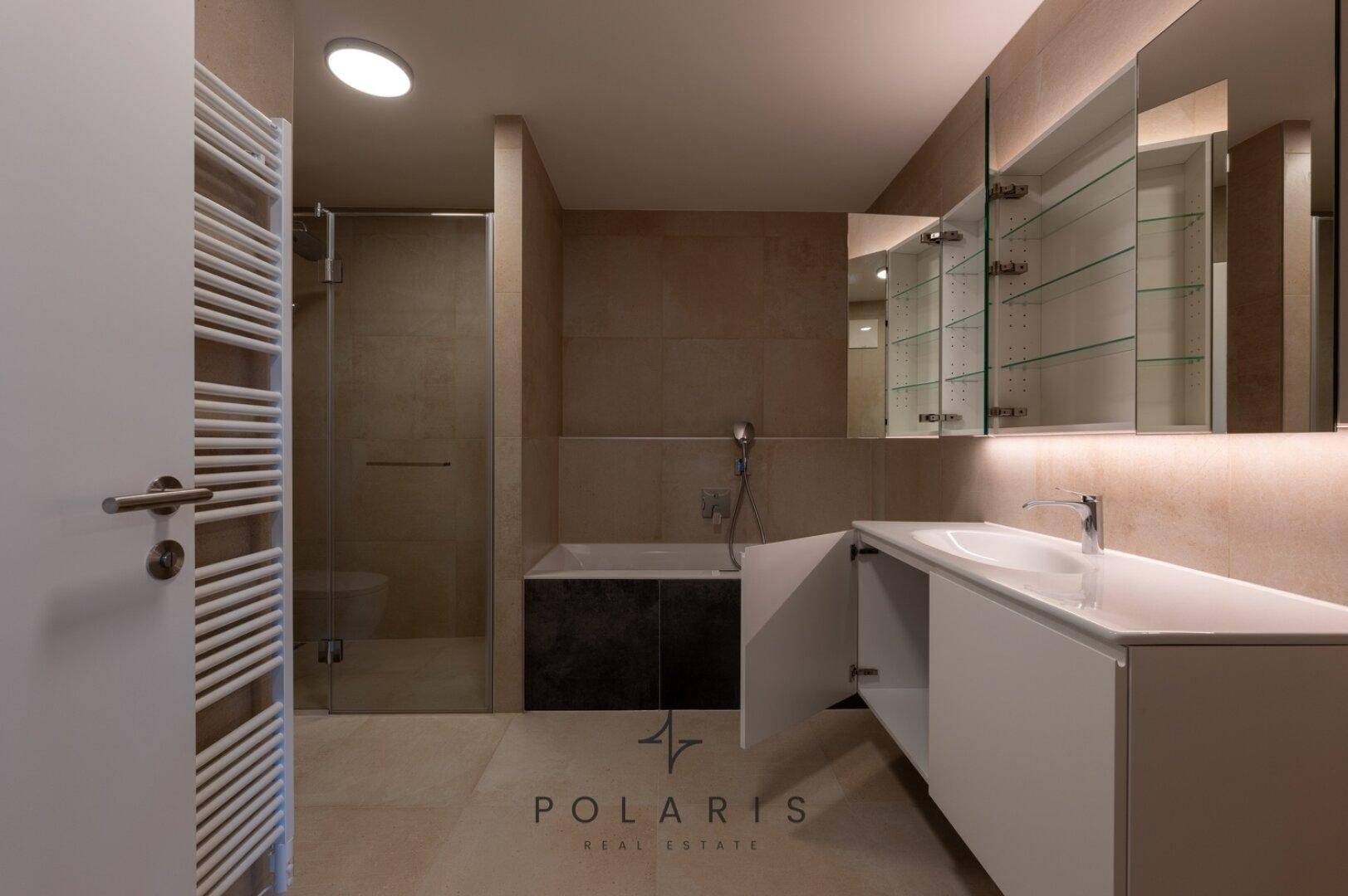 Modernes Badezimmer mit geöffnetem Spiegelschrank, Badewanne und Dusche, zeigt praktische Details.