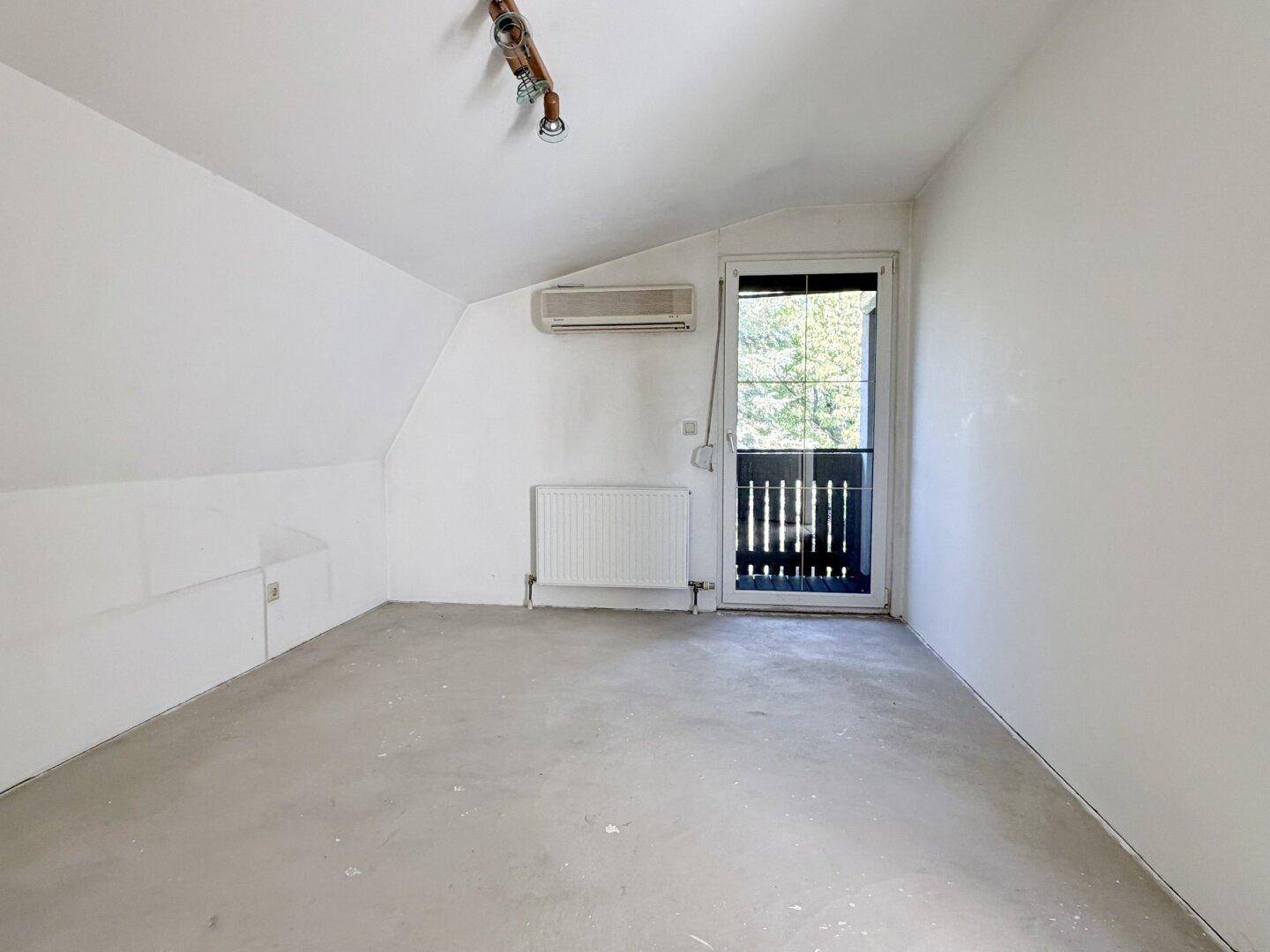 Helles Zimmer mit Balkonzugang, Klimaanlage und Dachschräge, ideal als Schlafzimmer.