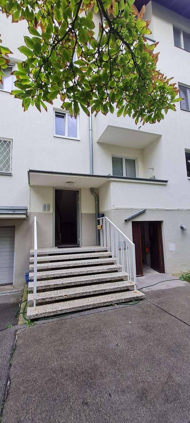 Eingangsbereich eines Wohnhauses mit Treppe und Zugang zu den Wohneinheiten.
