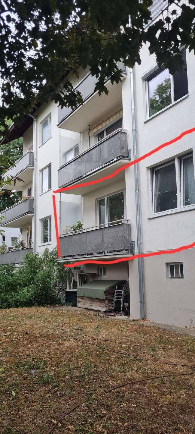 Seitenansicht des Wohnhauses mit mehreren Balkonen und umgebender Natur.
