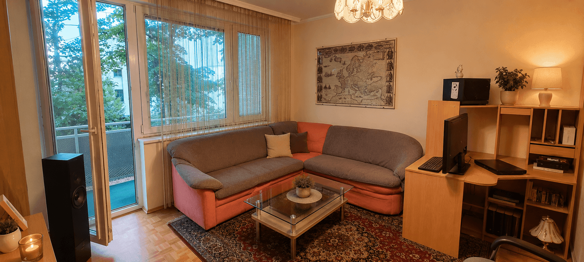 Geräumiges Wohnzimmer mit Ecksofa, Couchtisch und Zugang zum Balkon.