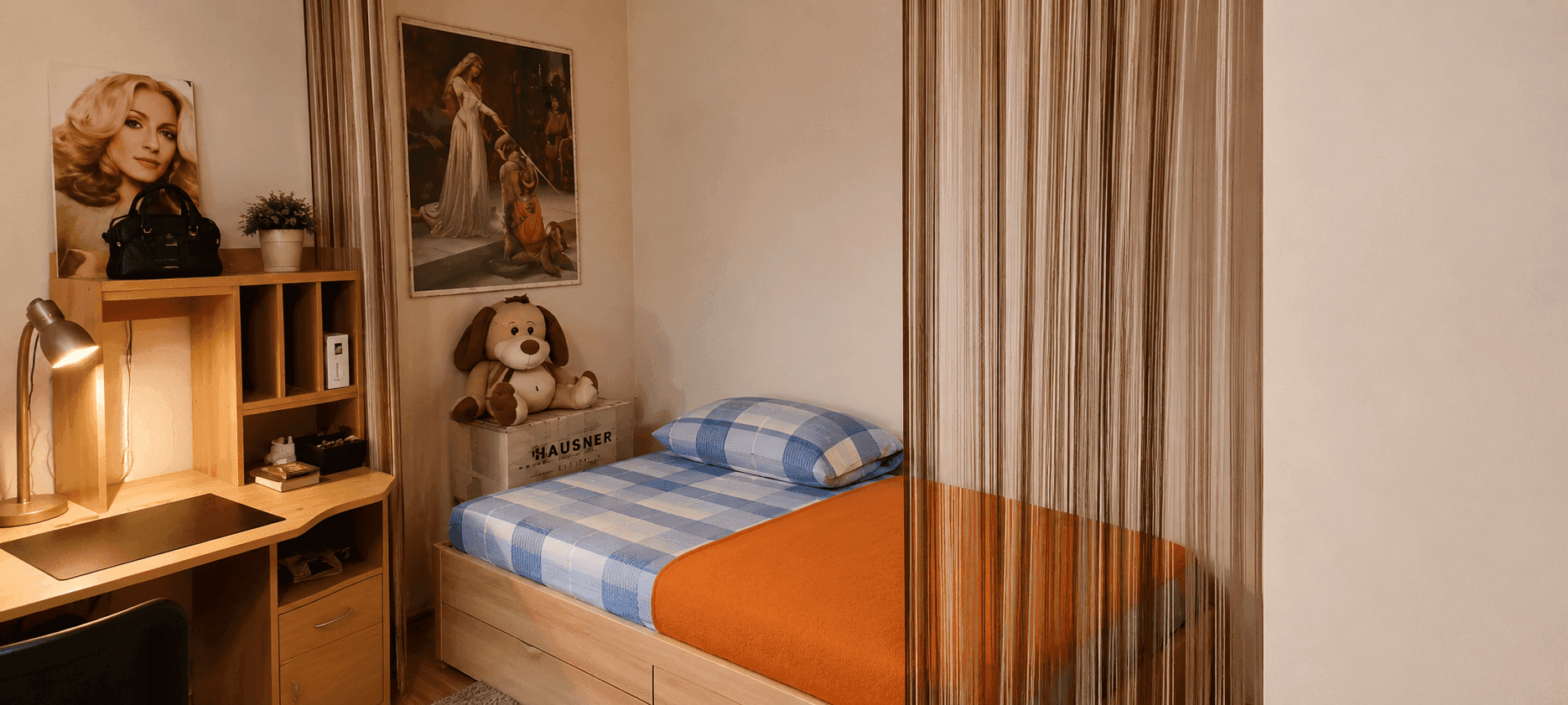 Helles Schlafzimmer mit Einzelbett, Schreibtisch und dekorativen Elementen.