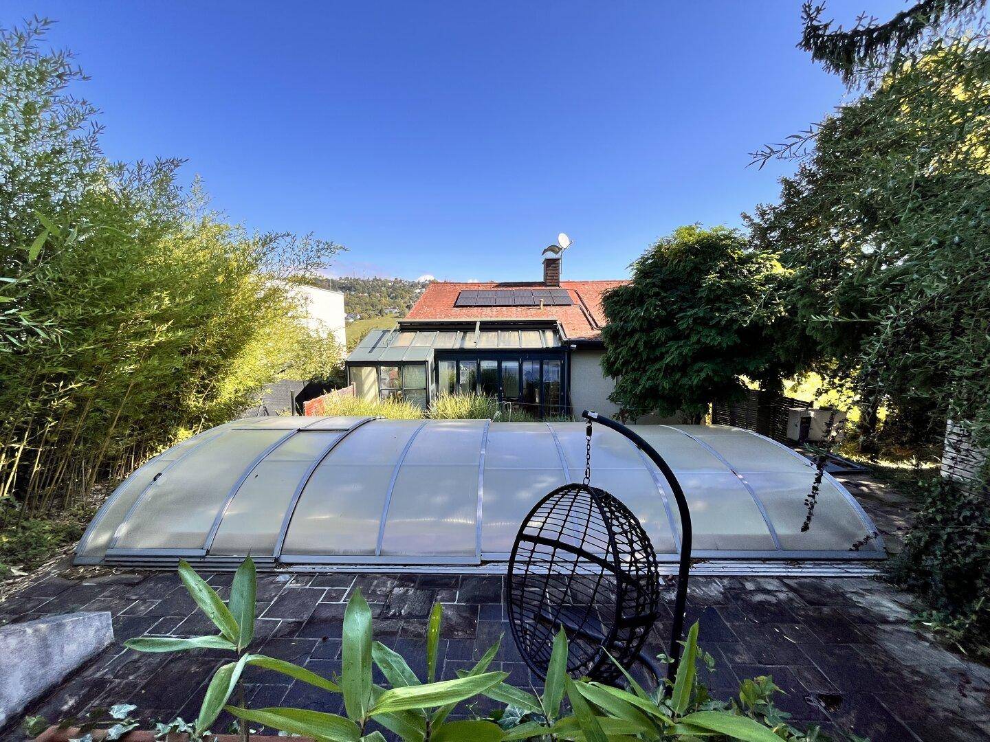 Garten mit Poolabdeckung, Hängesessel und Blick auf das Haupthaus.