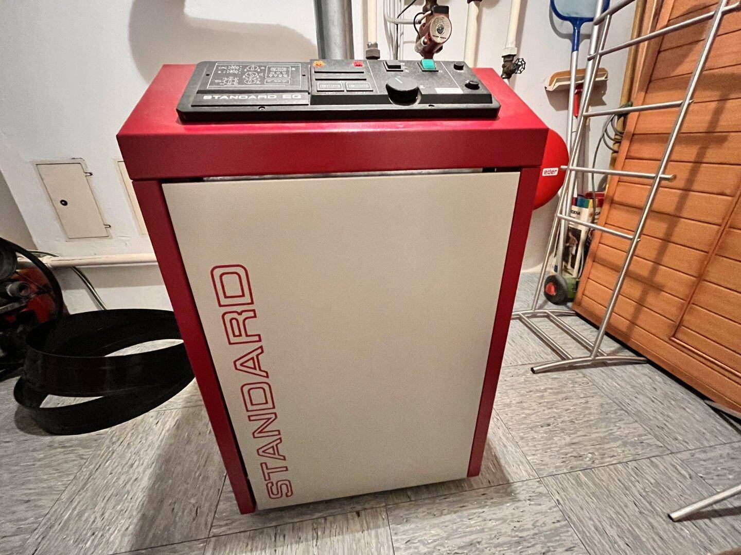 Heizungsanlage "Standard" in einem Technikraum mit Fliesenboden.
