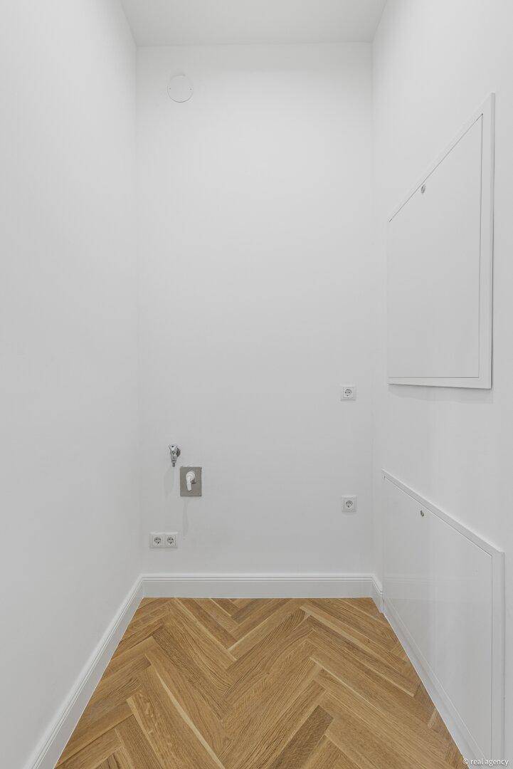 Kleiner Raum mit Anschlüssen für Waschmaschine und Trockner, ideal als Hauswirtschaftsraum.