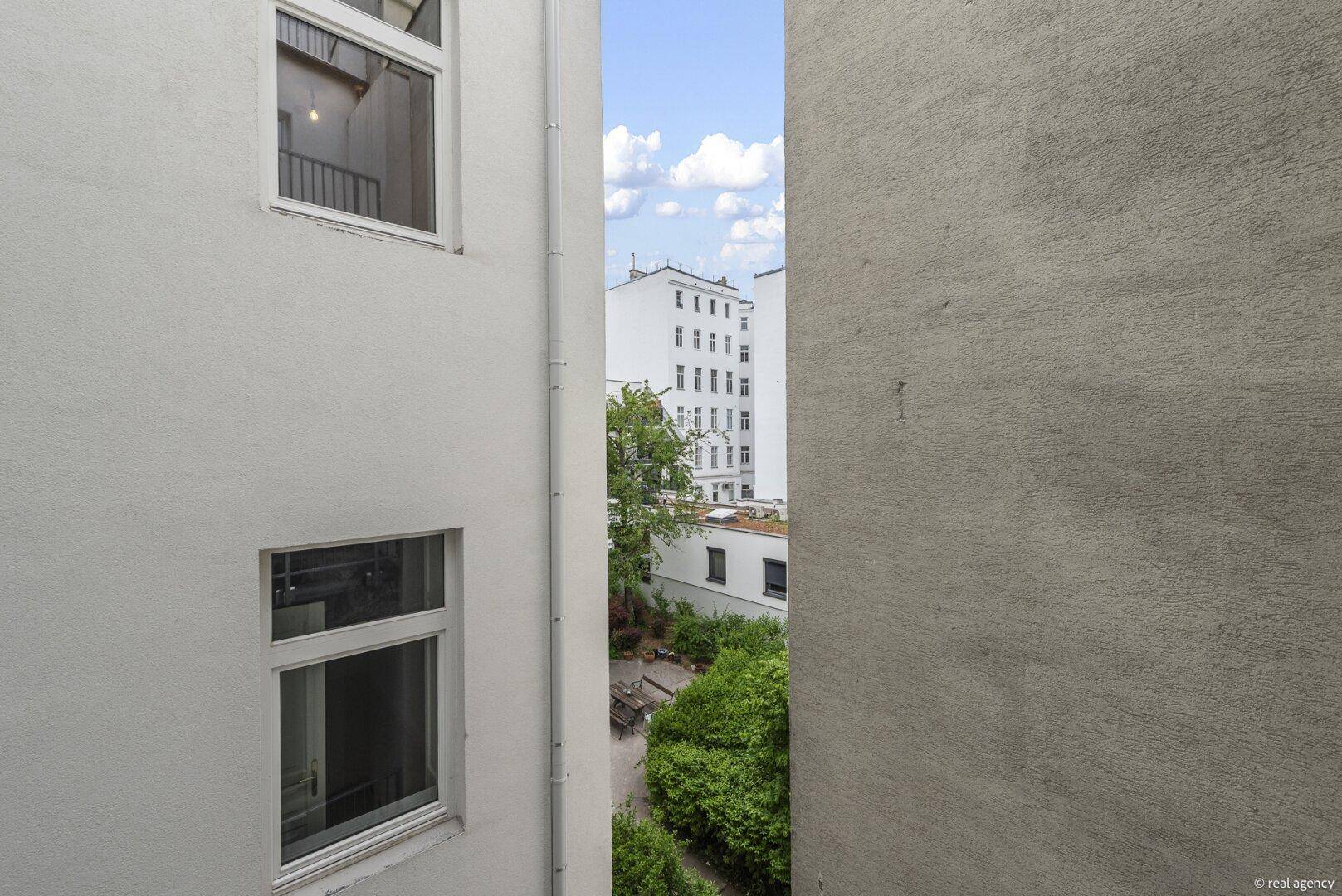 Balkon mit seitlichem Blick auf einen ruhigen Innenhof und die städtische Umgebung.