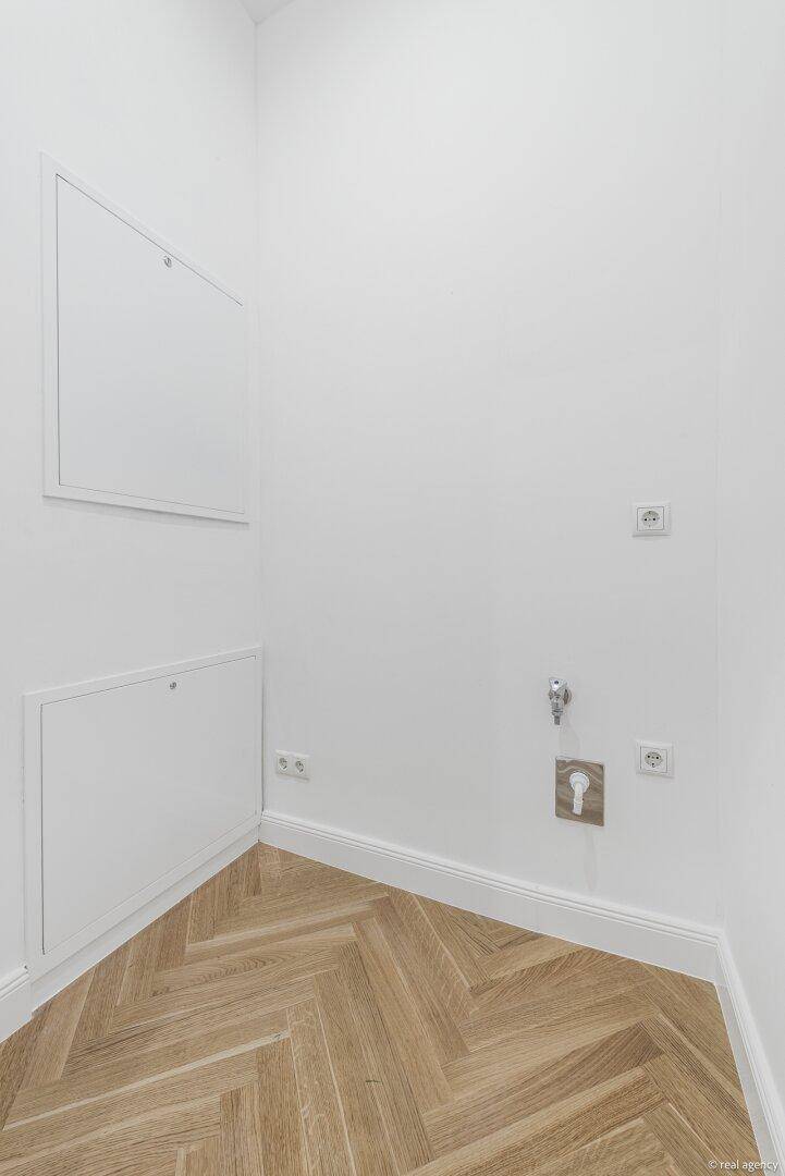 Leerer Raum mit Anschlüssen für Waschmaschine und Trockner, ideal als Hauswirtschaftsraum.
