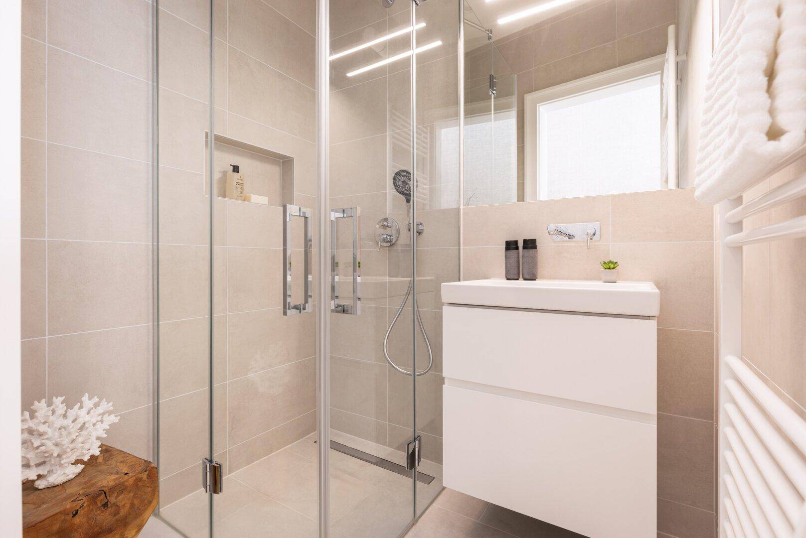 Modernes Badezimmer mit begehbarer Dusche, beigefarbenen Fliesen und Waschtisch.