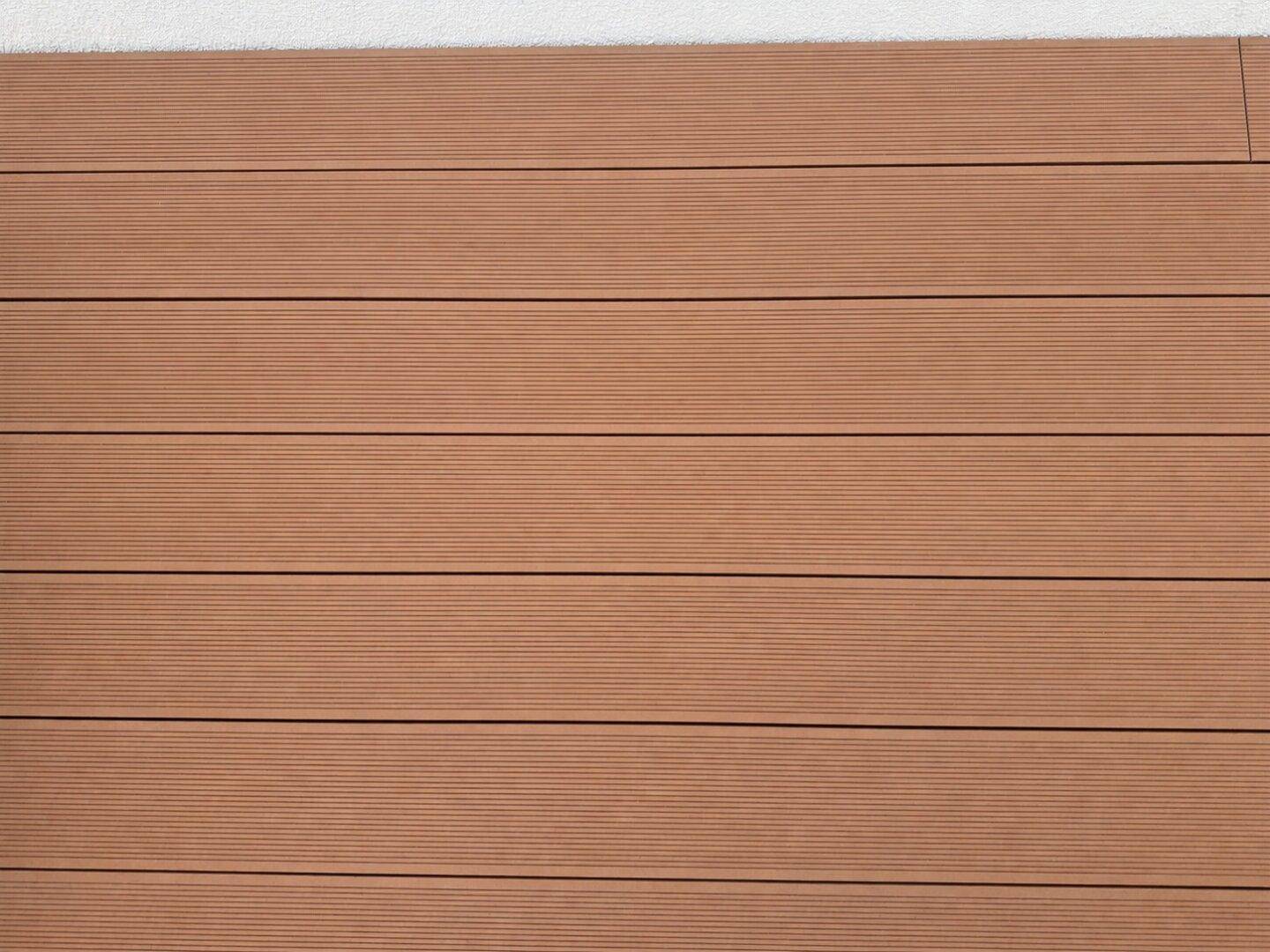 Detailaufnahme von braunen, geriffelten Terrassendielen aus Holzverbundwerkstoff.