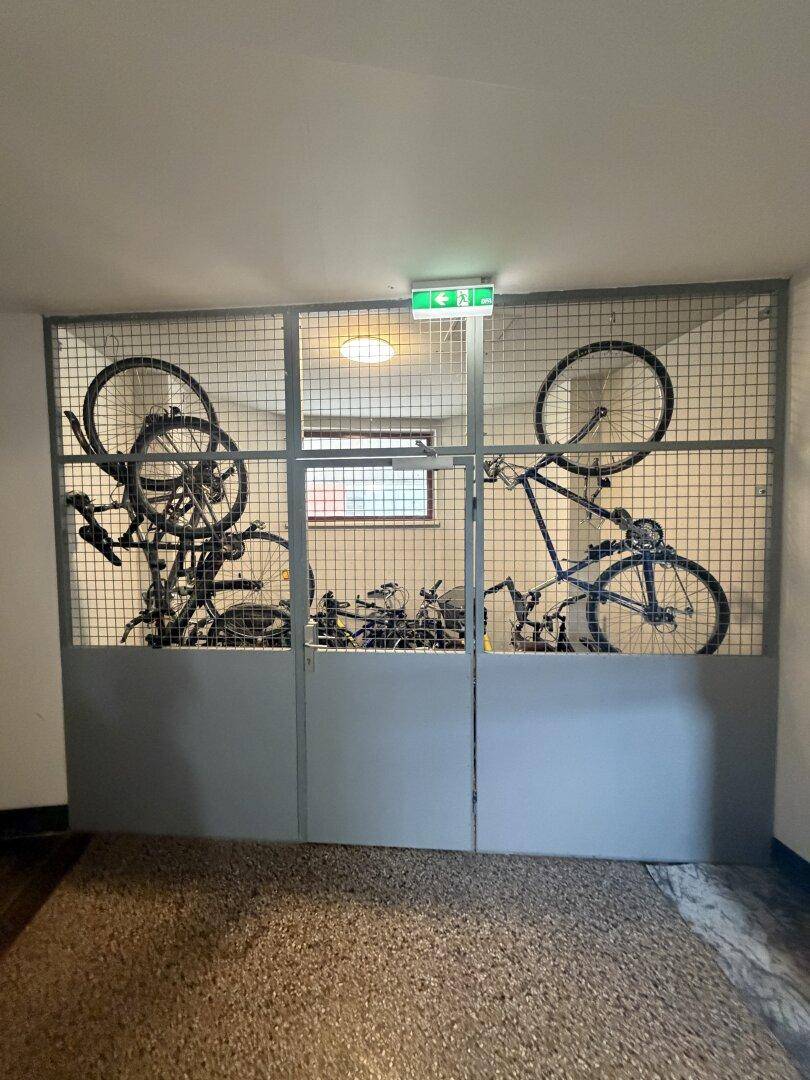 Abgeschlossener Fahrradraum im Gebäude mit mehreren Fahrrädern.