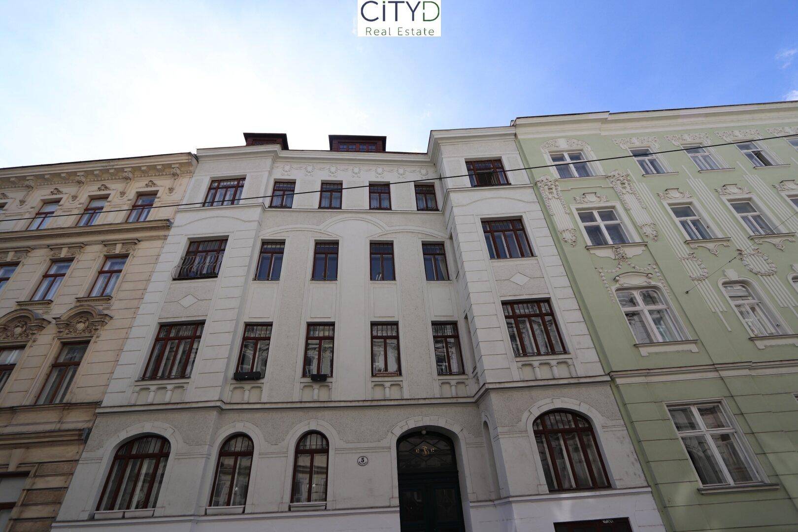 Fassade eines klassischen Altbaugebäudes mit vielen Fenstern und traditioneller Architektur.