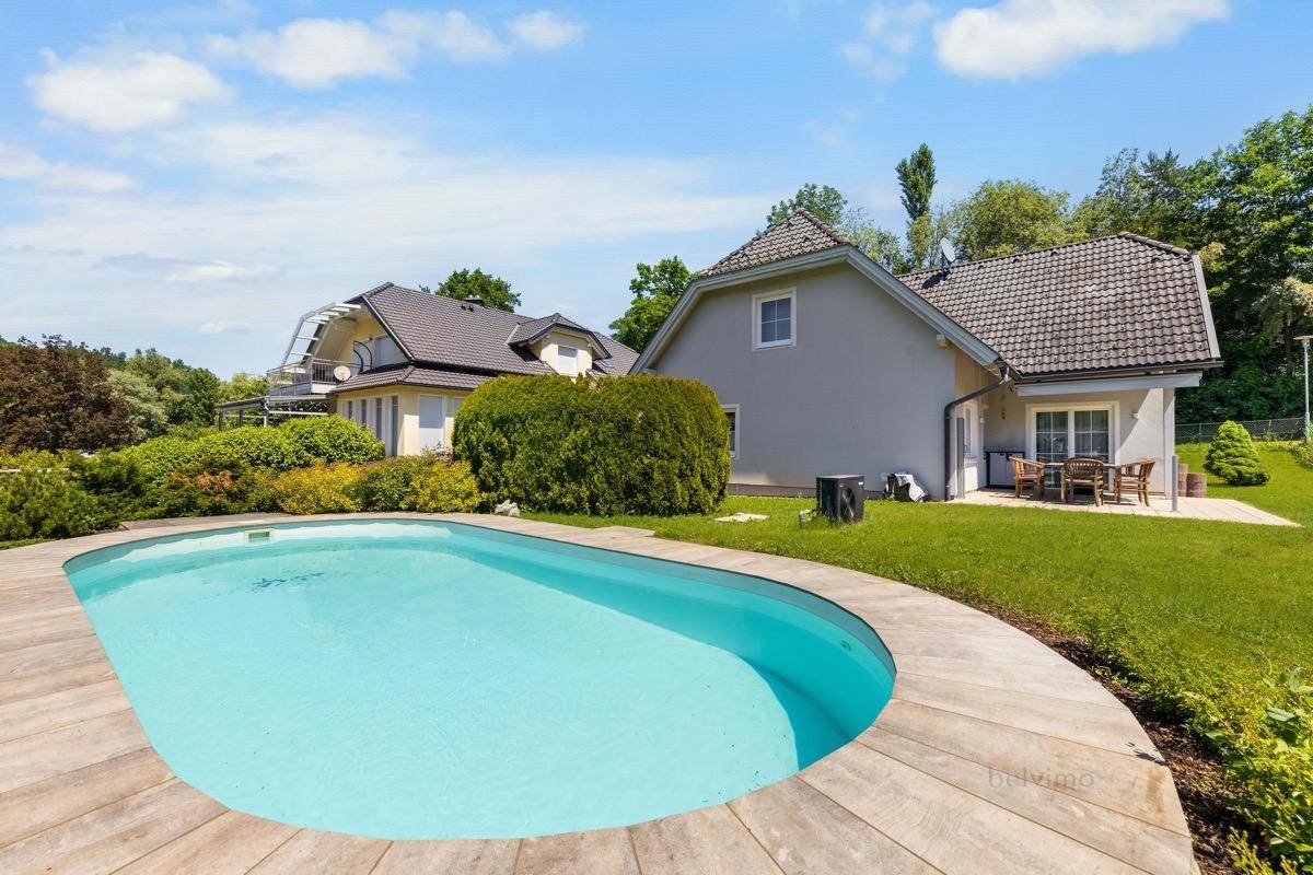 Ansicht des Hauses von außen mit großem Poolbereich und gepflegtem Garten.