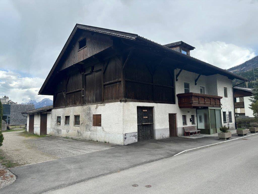 Außenansicht des Hauptgebäudes mit großem Scheunenanbau in ländlicher Umgebung.