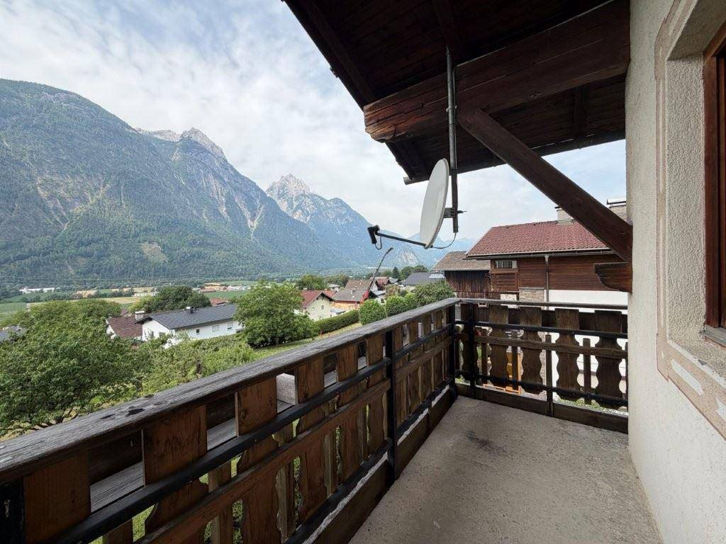 Balkon mit Satellitenschüssel und beeindruckendem Blick auf die Bergwelt und das Tal.