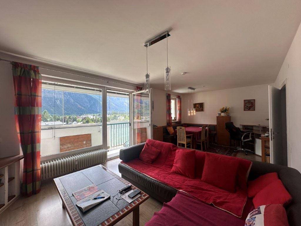 Gemütlicher Wohn- und Essbereich mit Zugang zum Balkon und Bergblick.