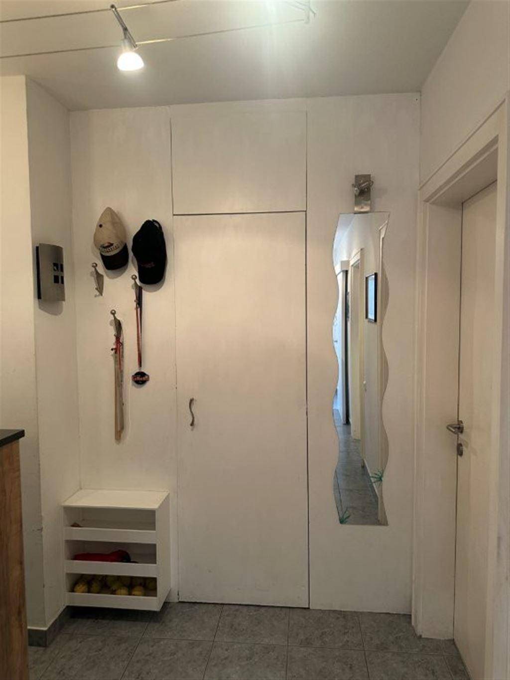 Eingangsbereich mit Garderobe, Spiegel und integriertem Stauraum.