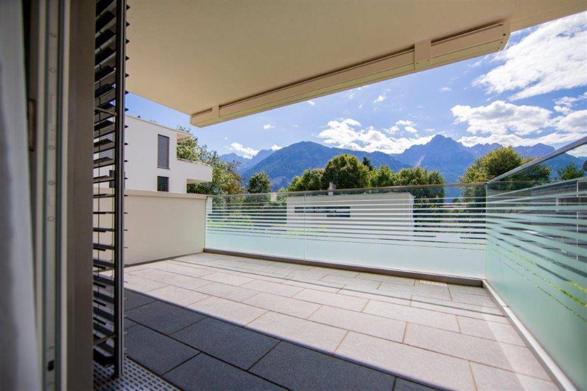 Geräumiger Balkon mit Fliesenboden und atemberaubendem Blick auf die umliegende Berglandschaft.
