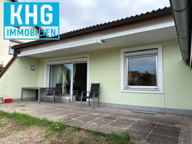 Gepflasterte Terrasse mit Gartenmöbeln und Zugang zum Haus.