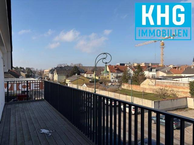 Großer Balkon mit Holzboden und Metallgeländer bietet einen weiten Blick über die Stadt.